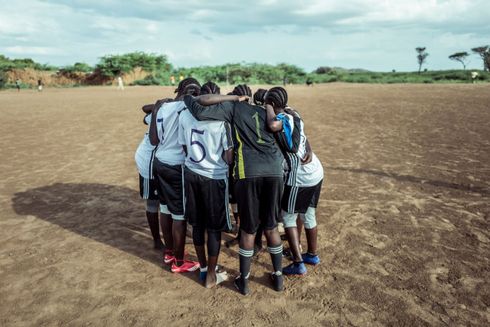 Spillerne står i en rundkreds inden kampstart.