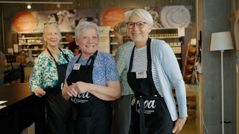 Tre smilende frivillige i Wefood, en butik med overskudsvarer, der drives af Folkekirkens Nødhjælp.