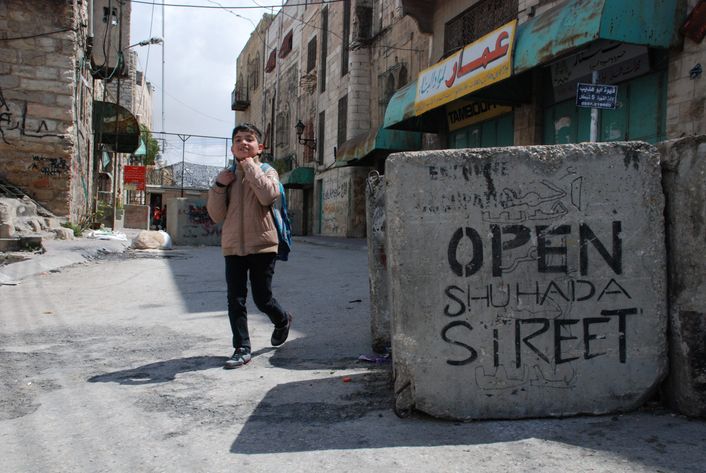 Dreng går med en rygsæk i Palæstina