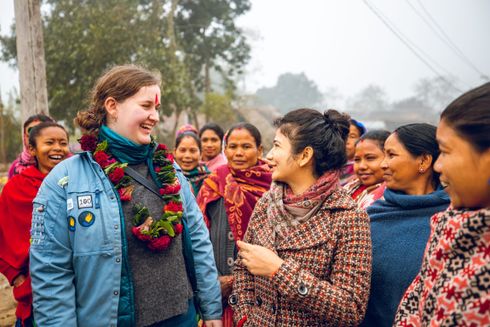 Kvinder snakker og smiler til hinanden