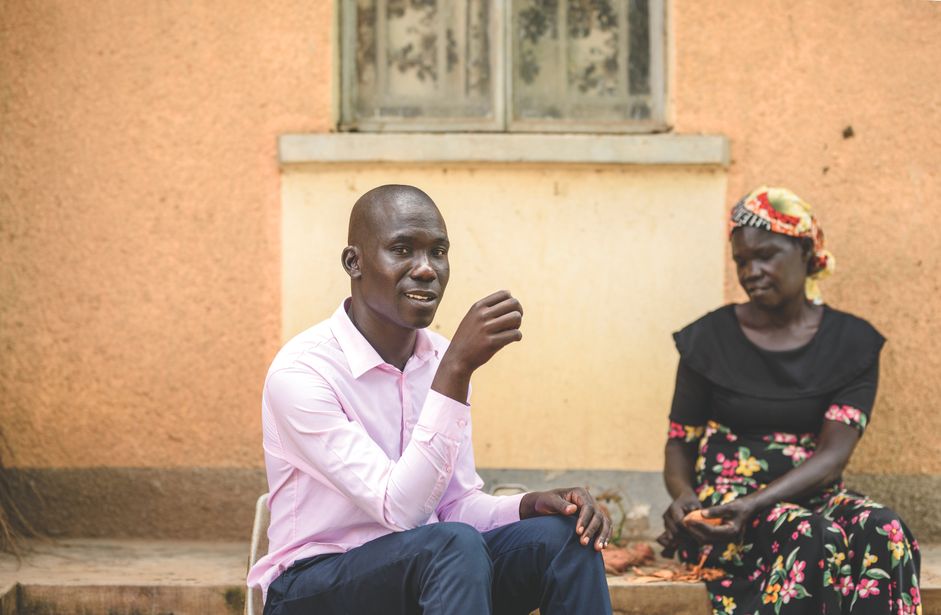 Mand poserer smilende mens kvinde skræller kartofler