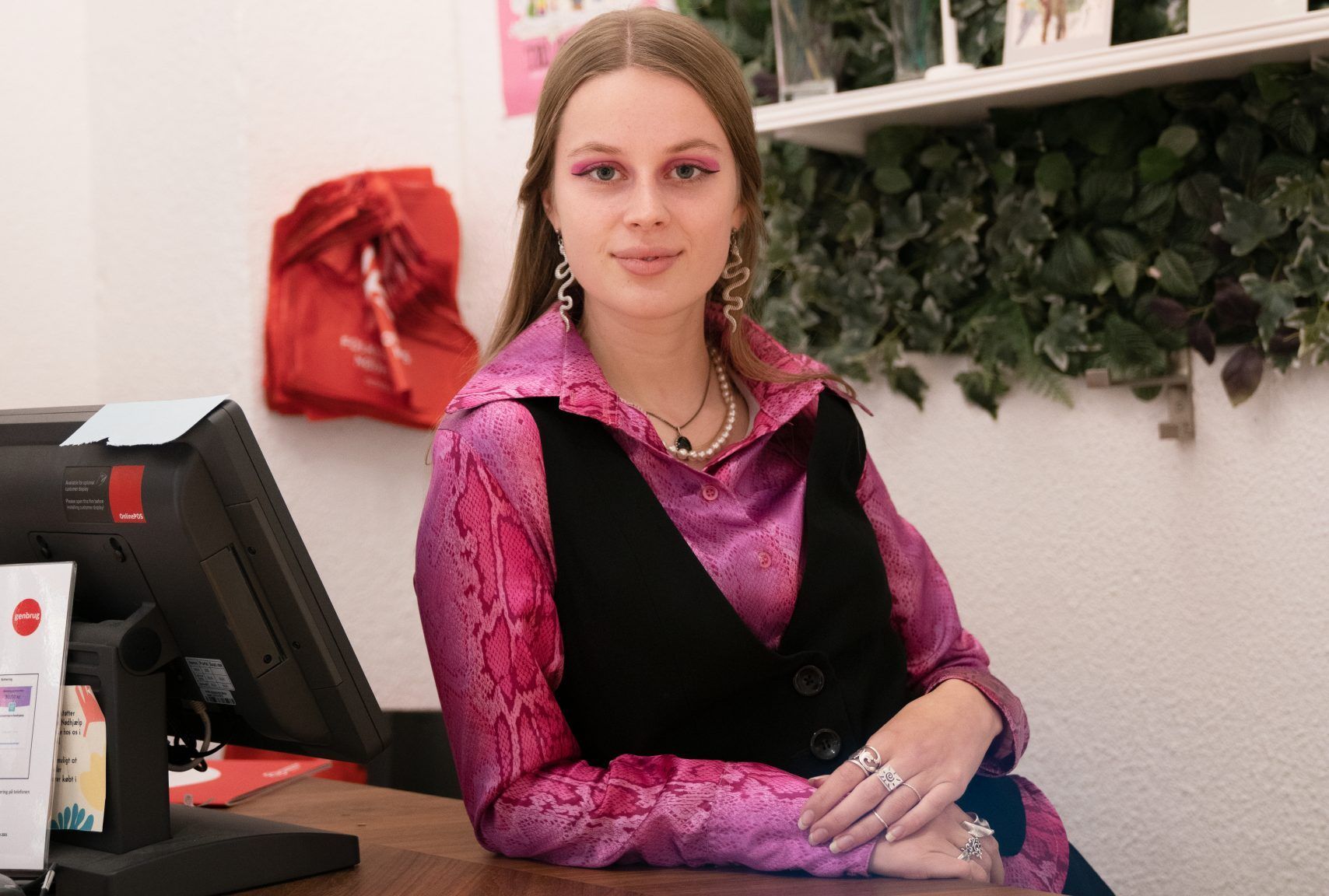 Solvig sidder ved kassen i en af Folkekirkens Nødhjælps genbrugsbutikker