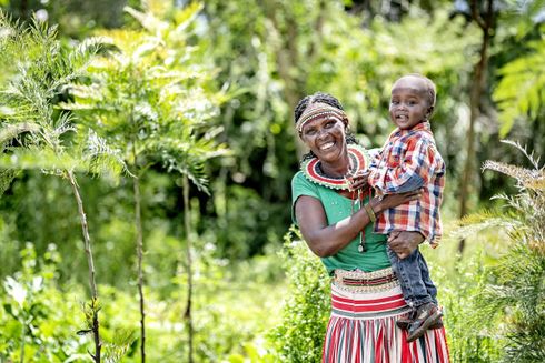Bedstemor og barnebarn står i køkkenhave