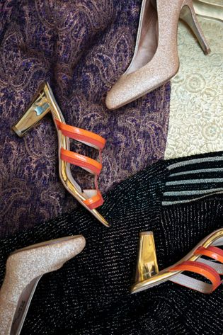 Stiletter ligger på nogle fine kjoler