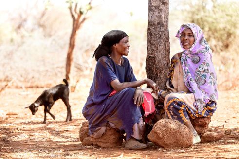 Rabla sidder med sin veninde under et træ - Folkekirkens Nødhjælp