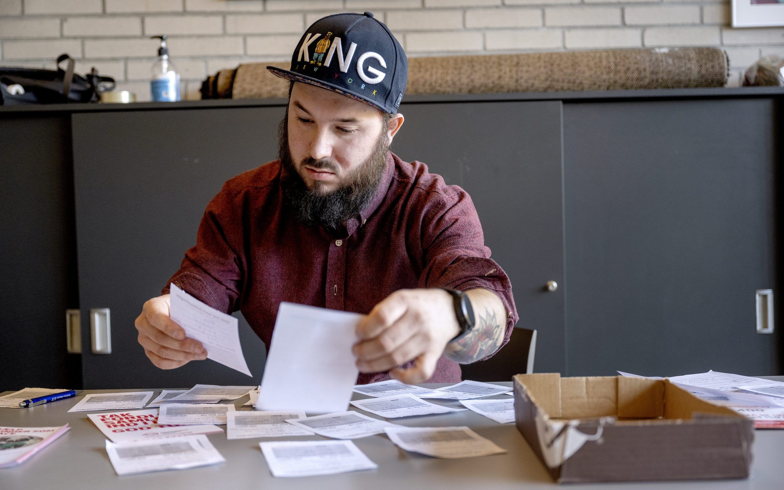 En mand sidder ved et bord og sorterer indsamlingsruter