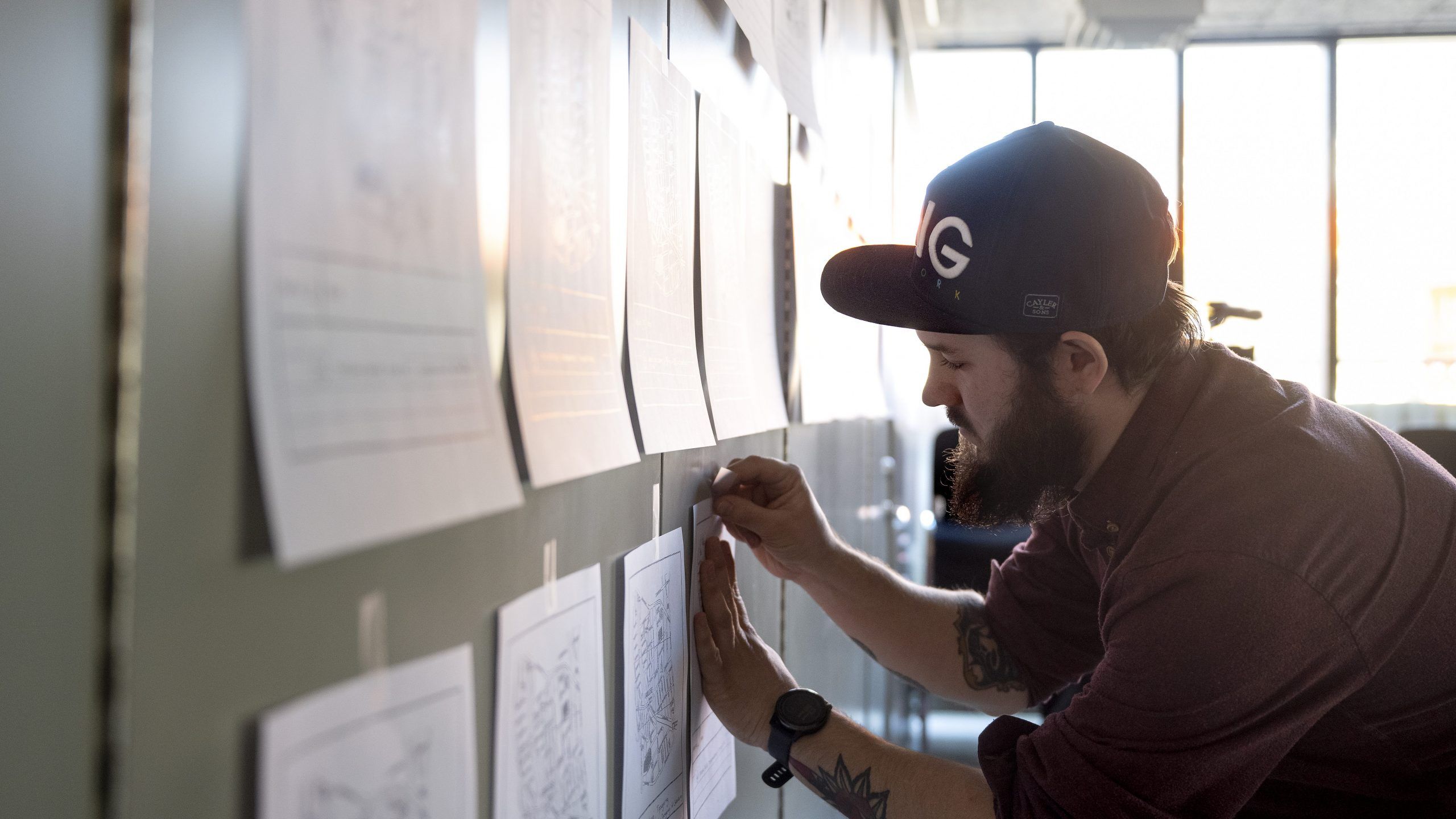 En mand hænger indsamlingsruter op på en væg