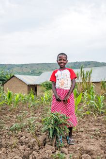 10-årige Brenda Atwijukire står ved siden af et af træerne, der blev plantet på hendes skole
