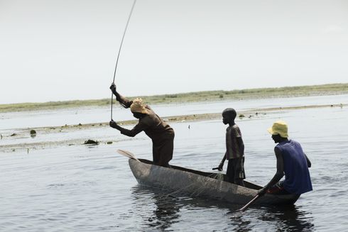 En kvinde og to mænd sejler i en båd og forsøger at fange fisk