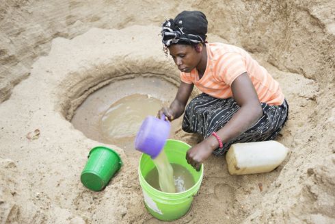 Kvinde samler vand i spande