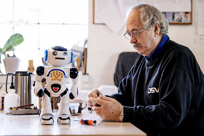 Mand sidder og samler en legetøjstrobot doneret til Folkekirkens Nødhjælp