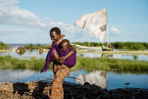 Etiopisk yngre kvinde bærer sin søster nær kyst