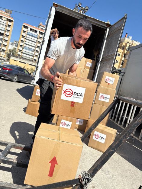 A DCA team member distributes hygiene kits to families in Dahye, Lebanon. The kits include essential hygiene items aimed at promoting health, cleanliness, and dignity among vulnerable communities.