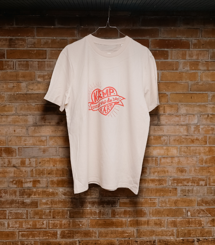 Varebiillede: Hvid æmp for alt. hvad du har kært-tshirt med rødt hængende på bøjle foran væg.