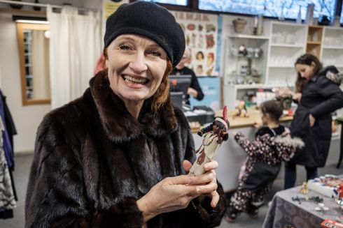 Ambassadør Bodil Jørgensen står i en genbrugsbutik med en legetøjsdukke i hånden