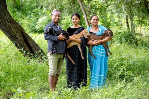 Mand og to kvinder holder hver især et gedekid i deres arme