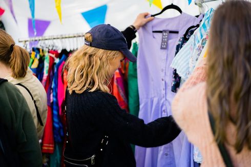 Kvinde i genbrugsbutik kigger på en kjole.
