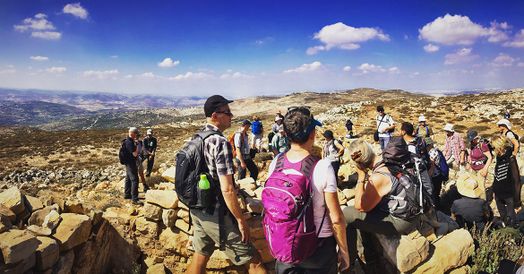 En gruppe mennesker som står i klippet miljø på vandretur.