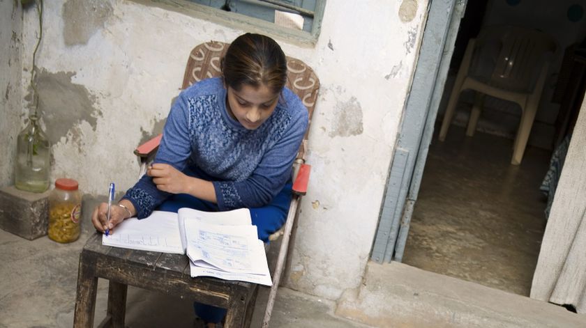 Kvinde sidder i stol og arbejder med blyant og papir