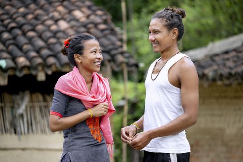 Hustru og mand smiler til hinanden ude foran deres hjem