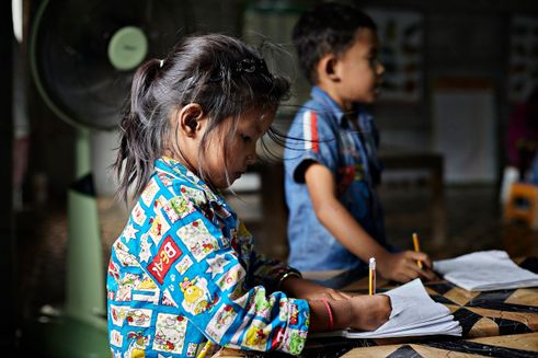 To skoleelever skriver i notesblok