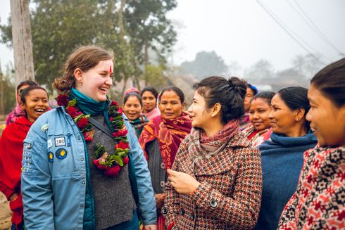 Kvinder snakker og smiler til hinanden